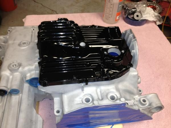 Finished powder coated oil pan setting on lower block that is ready to be coated.